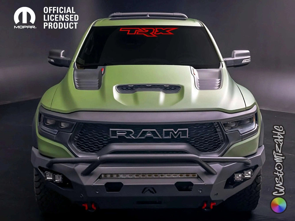 Green RAM truck with red TRX logo windshield decal, front view showcasing rugged design, custom grille, and off-road bumper against dark background