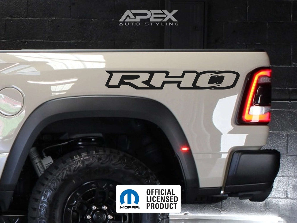 Ram RHO bedside decal on white truck, showcasing Apex Auto Styling branding and Mopar official licensed product logo, with visible rear taillight and wheel well